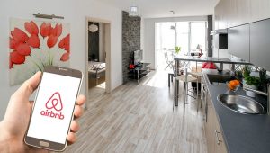 point of view picture of person holding air bnb app on phone in an apartment